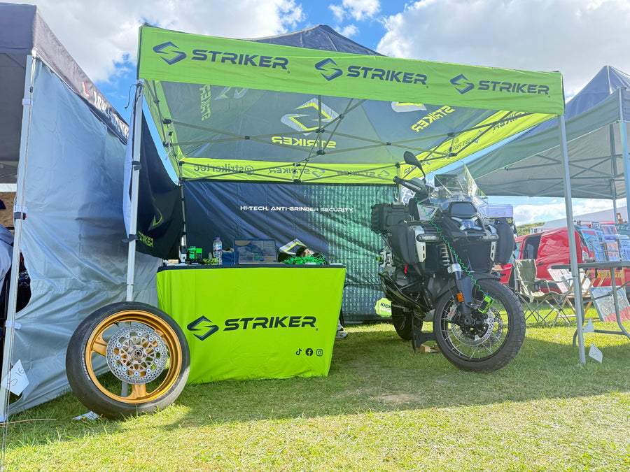 Motorcycle under a Striker branded canopy at an outdoor event